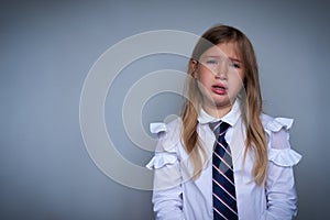 Small schoolgirl covering face, crying portrait