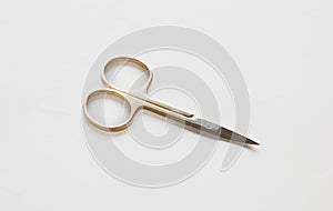 Small scissors. Steel nail scissors, gold hundle isolated on white