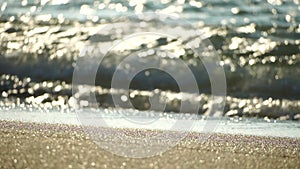 Small sea wave, Blurred Soft foamy waves washing golden sandy beach on sunset. Ocean Waves On Sandy Beach. Nobody