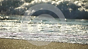 Small sea wave, Blurred Soft foamy waves washing golden sandy beach on sunset. Ocean Waves On Sandy Beach. Nobody