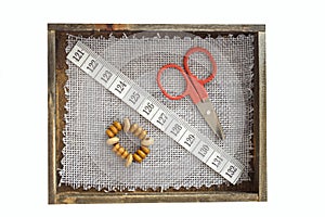 small sewing kit composition. scissors, tape measure and buttons in wooden box