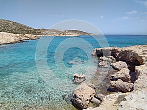 A small shingle beach on the quiet Greek island of Donousa. Crystal clear blue waters.