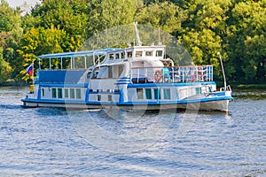 A small ship on the water illuminated by sunlight a background o