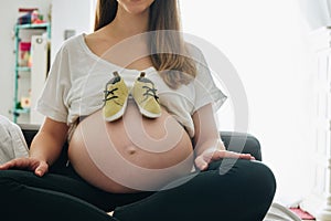 Small shoes in the belly of pregnant woman