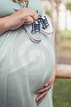 Small shoes newborn baby in belly of pregnant woman. preganancy concept
