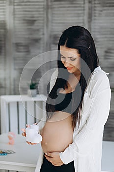 Small shoes for the unborn baby in the belly of pregnant woman