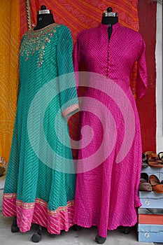 Small shop owner indian man selling shawls, clothing and souvenirs at his store. Colorful traditional Indian costume/outfit .