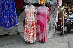 Small shop owner indian man selling shawls, clothing and souvenirs at his store. Colorful traditional Indian costume/outfit for