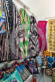 Small shop owner indian man selling shawls, clothing and souvenirs at his store.