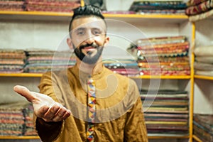 Small shop owner indian man selling shawls at his store in arambol goa