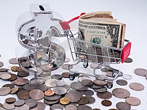 Small shopping cart with a financial symbol banknotes and coins and banknotes  exchange money using as shopping online or