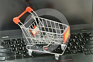 small shopping cart on laptop and computer screen background concepts shop on line