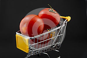 Small shopping cart with tomatoes on a white background