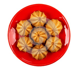 Small shortbread cookies in red saucer isolated on white. Top view
