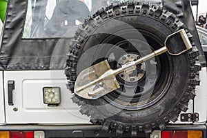 Small shovel and spare wheel in an off-road vehicle.