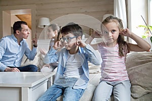 Boy and girl close ears not to hear parents quarreling photo