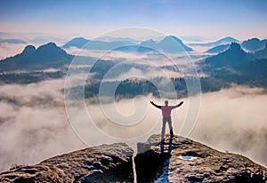 Small silhouette of hiker man enjoying  sunrise