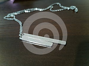 Small silver necklace with one longer and one shorter plate to make engraving on it and tiny chain