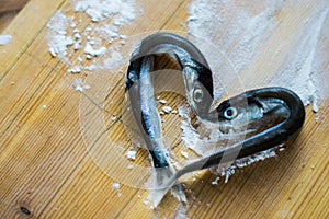 Small silver sea fish laid out in the shape of a heart