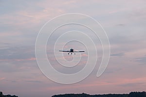 Small single engine airplane flying against sunset sky