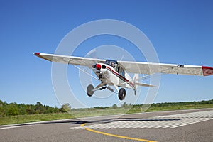 Small single engine airplane takes off from a municipal airfield in rural Minnesota