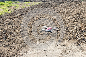 Small sized red drone with high resolution camera hovering in air for aerial photography