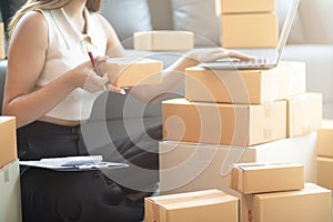 small sme entrepreneur is packing products into parcel boxes in preparation for transporting them to freight forwarder to deliver