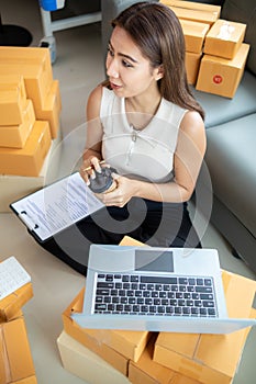 small sme entrepreneur is packing products into parcel boxes in preparation for transporting them to freight forwarder to deliver