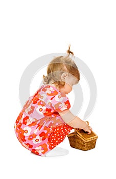 Small smiling baby in red dress with toy basket