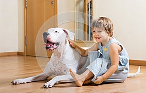 Small smiling girl on the floor with dog