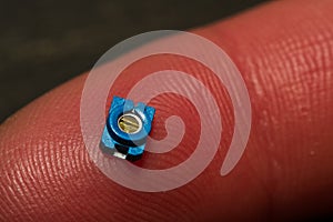 Small SMT Trim Pot Resistor Component On Finger photo