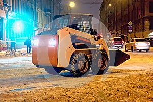 Small snow machine on the evening city street