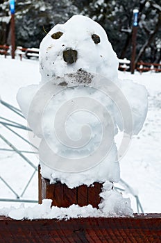 A small snowman on wooden fence at the foot of Cerro Bayo, touristic destination in Villa La Angostura, Neuquen, patagonia region