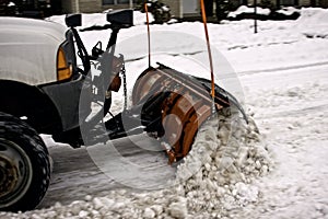 Small snowplow removing snow on a city street
