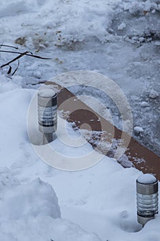 Small solar lamp covered with snow