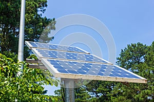 Small Solar Panel mounted on a pole in the summer with blue sky photo