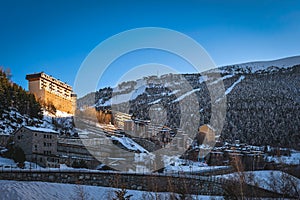 Small Soldeu town surrounded by pine forest and snow capped mountain range, Andorra