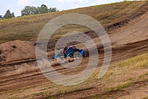 A small sports blurred buggy on a rally competition track during weekend training on a warm summer day