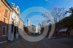 Small square at Murano island in Venice, with lighthouse in background