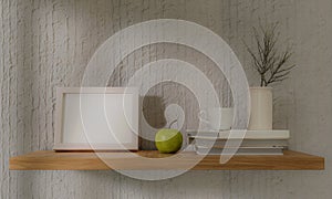 Small square wooden frame mockup in interior with trailing green apple, and shelf on empty neutral white wall background