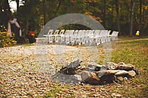Small stack of rocks with the white chairs for the guests of the wedding ceremony in the background