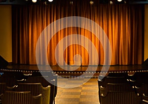 Small stage with orange curtains in cameral private cinema