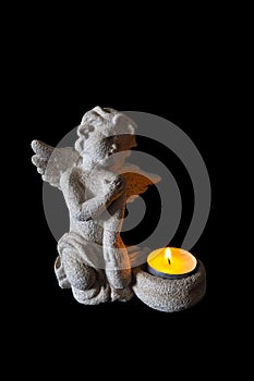 Small stone angel candle holder with a candle lit