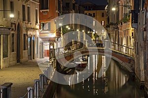 Small stone bridge spanning the Venetian canal by night