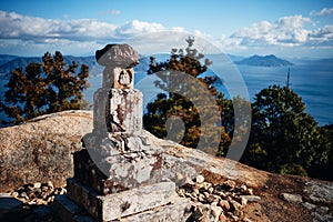 Small stone construction with a Jizo statue on the Misen mountain in Miyajima, Japan