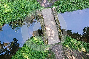 Small stone footbridge over calm stream. aerial photo