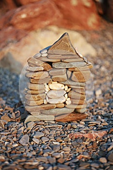 A small stone House construction on beach background