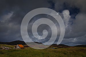 Small stone hut next to a Loch