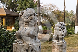 Small stone lions outside. Photographed in Mianyang.