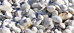 Small stone texture banner background. Pattern of white gray smooth seaside pebbles. Top view